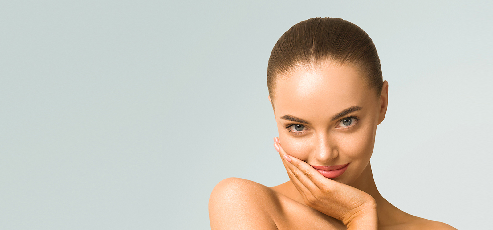 A woman is posing with her hand on her face.