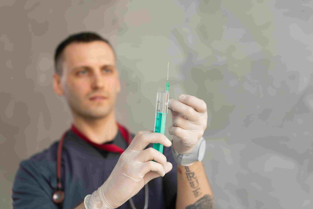 A healthcare professional wearing gloves prepares a syringe with green liquid, holding it upright and checking for air bubbles—offering one‑on‑one guidance on diet and scheduled follow‑up visits for optimal care.